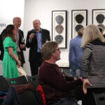 A room of people gathered in small groups talking at the Ecology annual general meeting 2024.