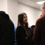 A woman speaking to a man at the Ecology annual general meeting 2024.