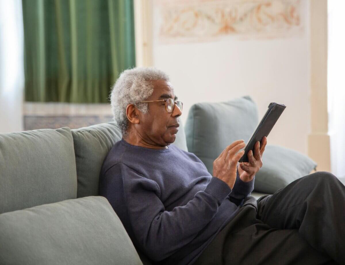 Man on a sofa searching for ethical savings accounts on an ipad